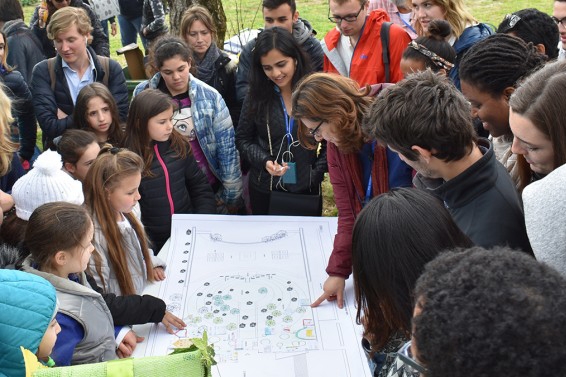A group of students and community members look at maps together