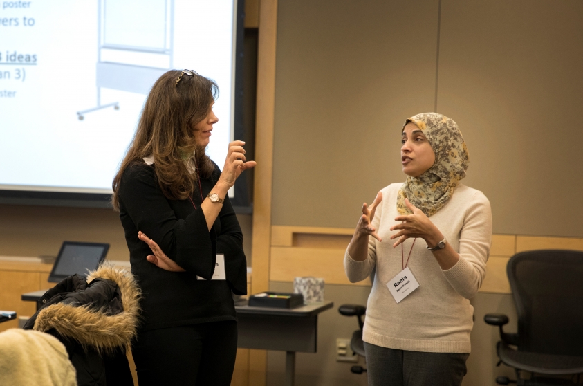 Two faculty members standing in a discussion