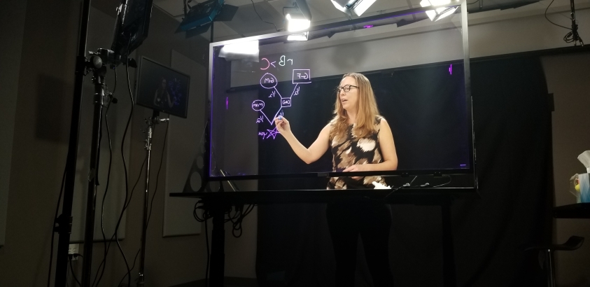 Woman writes on light board