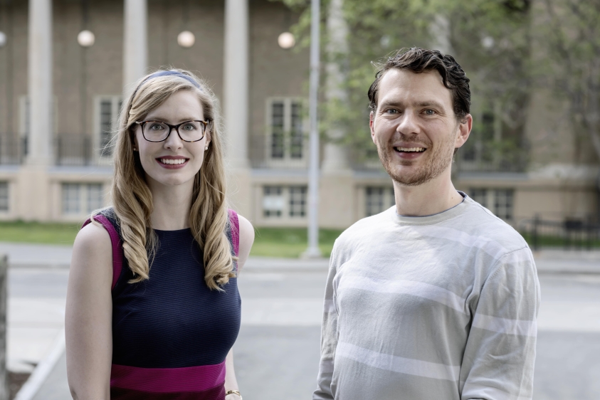 Blonde woman and brunette man stand outside in spring
