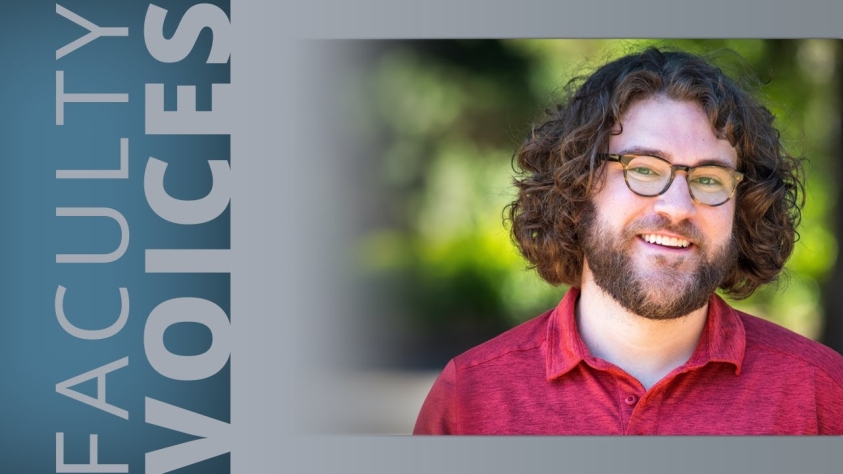 Young man with brown hair, black glasses and beard