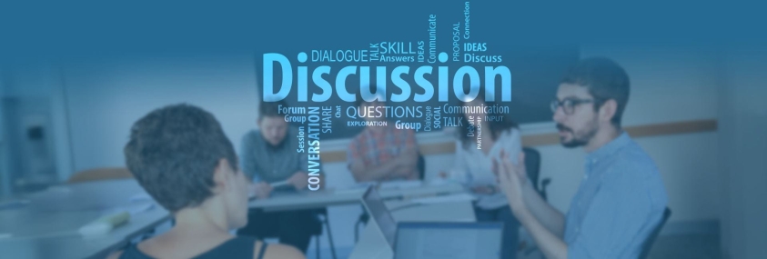 Faculty talk beneath a word cloud