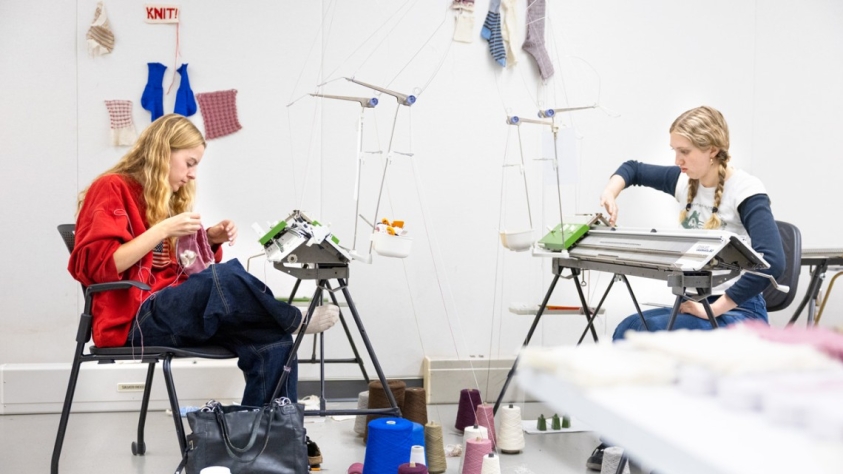 Two students make knitted socks using wool grown and spun in New York state