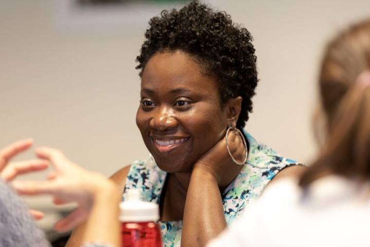 Close-up of faculty member smiling while engaged in a discussion