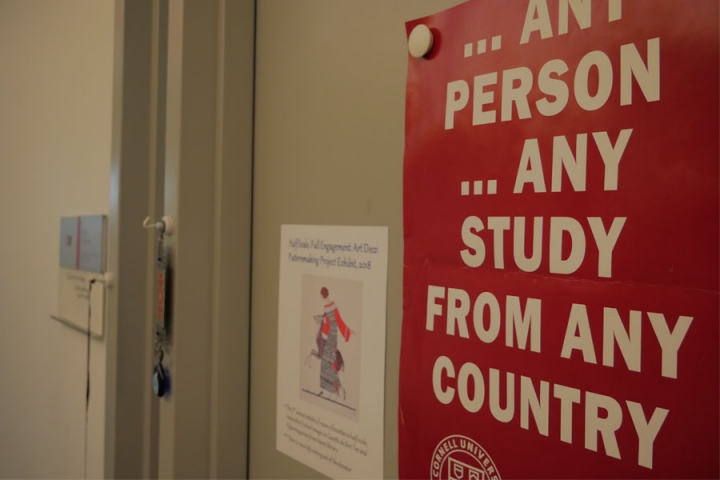 Sign reading “Any person any study from any country” on an office door