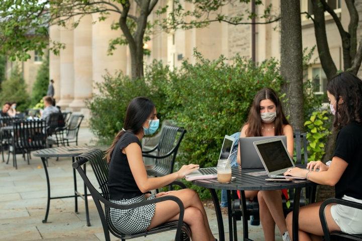 Students working on computers at outdoor table