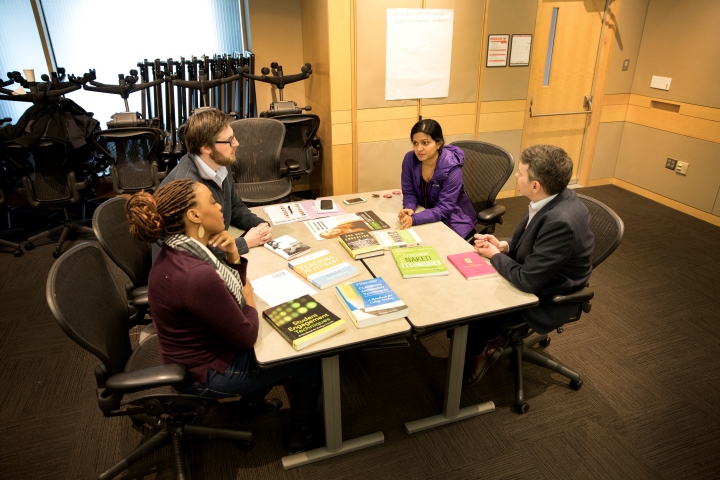Faculty discussing around a table