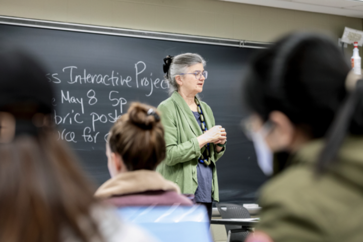 Instructor stands at the front of a classroom