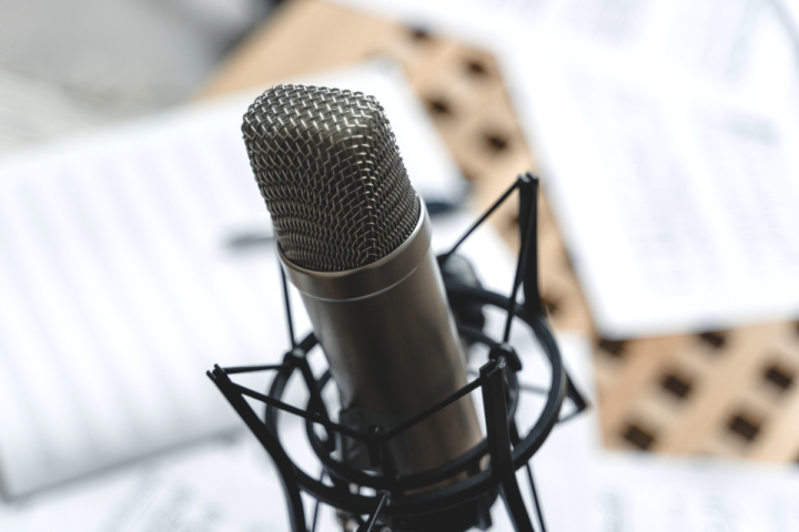 A microphone in a recording studio, backdrop includes script