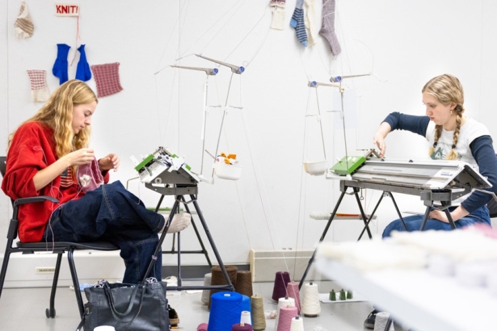 Two students make knitted socks using wool grown and spun in New York state