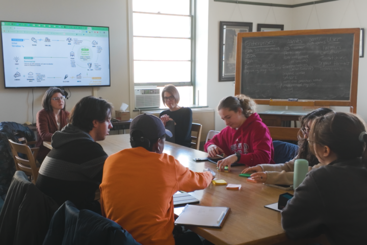Faculty members work with students on a project